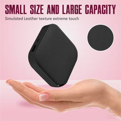 Black rectangular device with textured surface held in a hand against a pink background